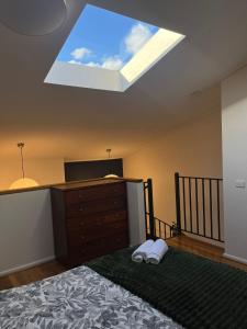 a bedroom with a bed and a skylight at Brickworks Heritage Loft in Melbourne