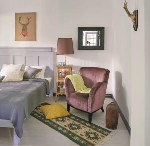 a bedroom with a bed and a chair next to a bed at Ceruzás ház in Nagyrákos