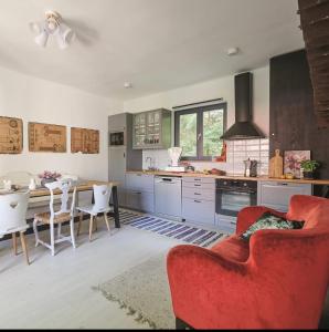 cocina con sofá rojo, mesa y sillas en Ceruzás ház, en Nagyrákos