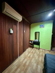 a room with a green wall and a mirror at AISHAH GUEST HOUSE in Perhentian Islands