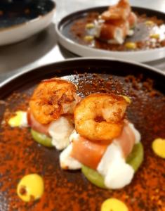 a plate of food with shrimp and vegetables in sauce at Ferienhaus by Rossano Boutique Hotel & Ristorante in Ansbach