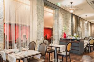 a restaurant with tables and chairs and a counter at Logis Grand Hôtel Des Bains in Salins-les-Bains