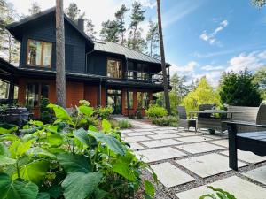een huis met een stenen patio ervoor bij Villa VILAVI Jurmala in Jūrmala