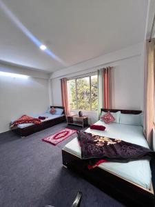 Un dormitorio con dos camas y una ventana. en Nimbus Soulstay, en Kalimpong