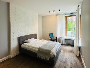 een slaapkamer met een bed en een stoel erin bij Villa VILAVI Jurmala in Jūrmala