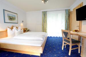 a hotel room with a bed and a desk at Hotel Garni Valülla in Ischgl