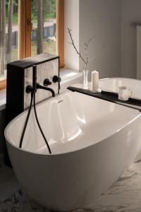 een badkamer met een wit bad en een raam bij Villa VILAVI Jurmala in Jūrmala +31 foto's