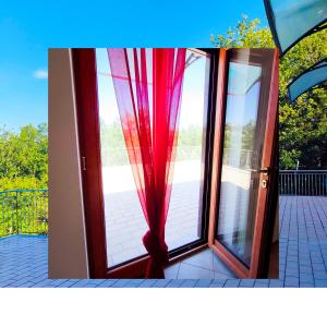 an open glass door with a red curtain at L'angolo segreto di Beltiglio in Beltiglio San Giovanni