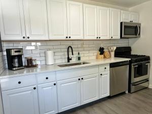 BereaにあるKING bed, Pet Friendly, Modern Retreat in CLE-BWの白いキャビネットとシンクのあるキッチン +6枚の写真