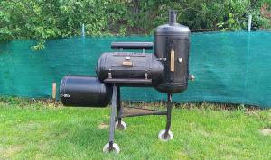 a stove and suitcase sitting in the grass at Vándor Kakas Vendégház dézsafürdővel in Recsk