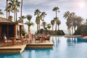 帕福斯Annabelle的一个带游泳池的度假村,人们坐在桌子上