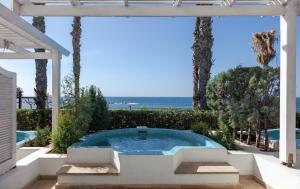 a hot tub in a patio with the ocean in the background at Annabelle in Paphos