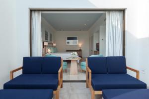two blue chairs in a room with a bedroom at Annabelle in Paphos