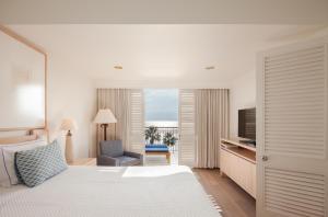 a hotel room with a bed and a chair and a television at Annabelle in Paphos +159 photos