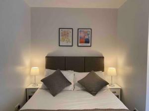 a bedroom with a bed with two lamps on it at Dream Yard Apartments Westcliff in Southend-on-Sea