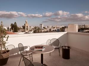 a balcony with a table and chairs and a view of a city at Amyth of Nicosia in Nicosia