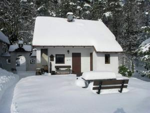 a house covered in snow with a bench in front of it at Chalet in Malá Skála near Ski Slopes in Malá Skála