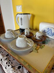 a table with plates and cups and a coffee maker at Assisi il Panorama in Petrignano