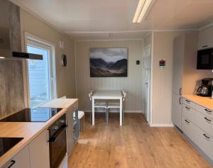 a kitchen with a table and a small table in it at Oppmyre Camping in Myre +16 photos