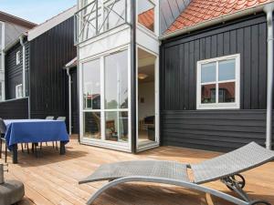 a patio with a table and chairs on a wooden deck at Spa Retreat by the Canal - By Traum Ferienwohnungen in Juelsminde