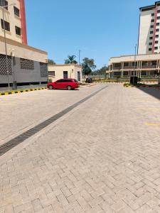 a red car parked in the middle of a parking lot at Okoko Enterprises BnB in Kisumu