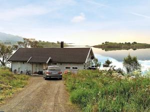 ein Auto, das vor einem Haus auf einer unbefestigten Straße parkt in der Unterkunft 11 person holiday home in Gullesfjord in Flesnes