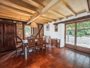 a dining room with a table and chairs and windows at Évasion totale, maison de charme en pleine nature in Razengues