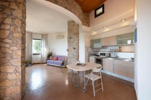 een keuken en woonkamer met een tafel en stoelen bij Il Torrino in Campiglia Marittima