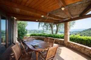 een houten tafel en stoelen op een patio met uitzicht bij Il Torrino in Campiglia Marittima