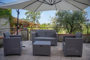 eine Terrasse mit zwei Stühlen und einem Sonnenschirm in der Unterkunft Sun House in Santa Maria del Cedro