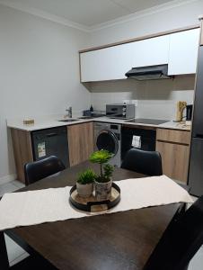 a kitchen with a wooden table with a table sidx sidx sidx at Luxury Apartment at The Blyde Crystal Lagoon in Pretoria