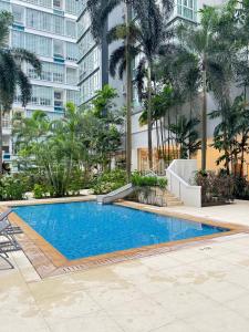 ein Swimmingpool vor einem Gebäude mit Palmen in der Unterkunft KLCC Marc Residence by AZ Line in Kuala Lumpur