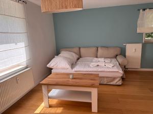 a small bedroom with a bed with a wooden table at Landhaus Buckow in Buckow