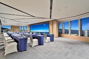 a conference room with blue tables and white chairs at voco Zhoushan Putuo by IHG in Zhoushan