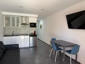 a kitchen and living room with a table and chairs at Wonderful stay in Tenerife Royal Gardens Resort! in Playa de las Americas