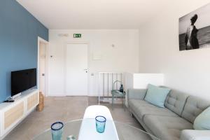 a living room with a couch and a tv at Sitges Blue - completamente reformado en 2025 in Sitges