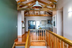 a hallway with a staircase leading to a kitchen with wooden ceilings at 7 On Boardwalk in Wilderness +6 photos