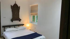 a bedroom with a bed and a clock on the wall at Tranquil 2-Bedroom Getaway in Selina Serenity Phuket - Selina #870 in Ban Saiyuan (1) +29 photos