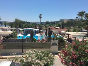a resort with a pool and tables and umbrellas at Malibu Summer Studios in Dassia