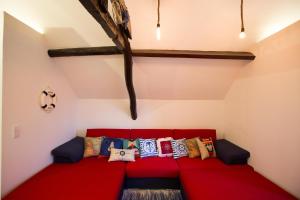 un sofá rojo con almohadas en una habitación en Ribeira Flats MyGod en Oporto