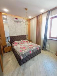 a bedroom with a bed with flowers on it at DREAM HOUSE TASHKENT Airtport in Stantsiya Kyzyl-Tukumachi +12 photos