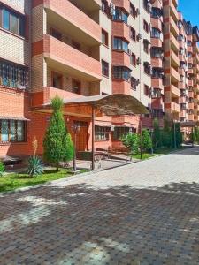 a large brick building with an umbrella in front of it at DREAM HOUSE TASHKENT Airtport in Stantsiya Kyzyl-Tukumachi