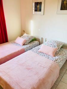 two beds sitting next to each other in a room at Villa Les hortensias RDC in Maniquerville