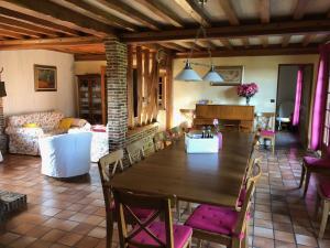a dining room and living room with a table and chairs at Villa Les hortensias RDC in Maniquerville +6 photos
