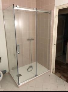a shower with a glass door in a bathroom at Villa Les hortensias RDC in Maniquerville