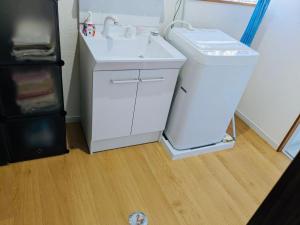 a bathroom with a white sink and a refrigerator at Amami North Mangrove Inn - Vacation STAY 90032v in Amami