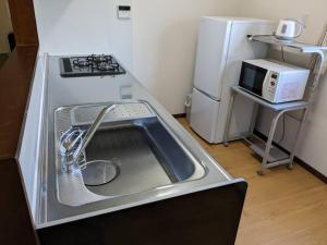 a kitchen with a sink and a stove and a refrigerator at Amami North Mangrove Inn - Vacation STAY 90032v in Amami +21 photos