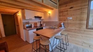 eine Küche mit einer Theke und Hockern in einem Zimmer in der Unterkunft Cocon au cœur des Montagnes in Puyvalador