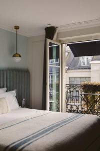 a bedroom with a bed and a large window at Hotel Bachaumont in Paris