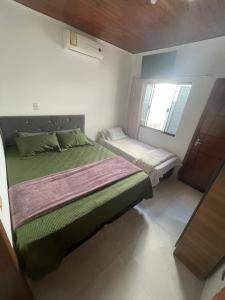 une petite chambre avec un lit et une fenêtre dans l'établissement Casa Privativa com Quarto Confortável e Cozinha Ótima Localização em Foz do Iguaçu, à Foz do Iguaçu